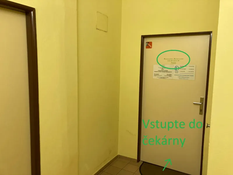 Konec chodby se světlými dveřmi; na nich zakroužkovaná cedule centra a zeleně dopsaná slova „Vstupte do čekárny“. Zelená šipka ukazuje na dveře.